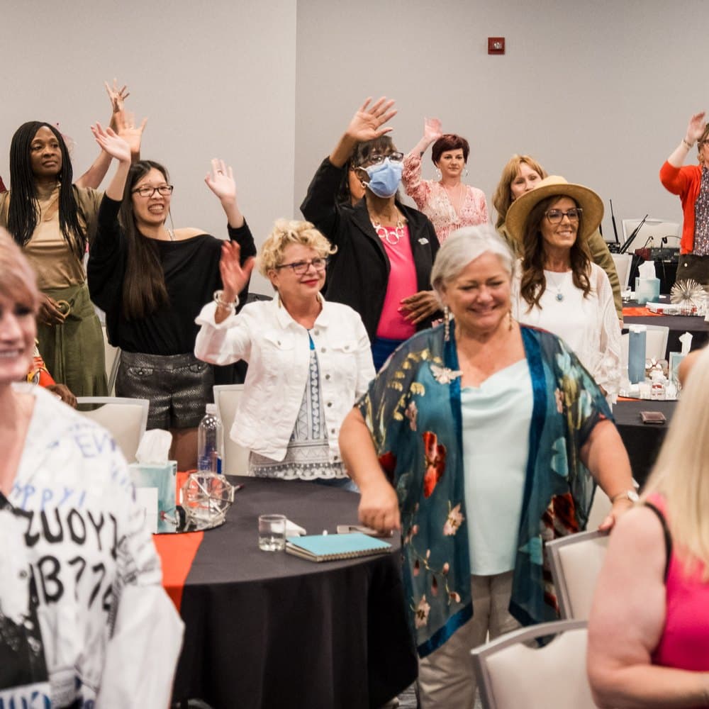 Delegates with their hands in the air during a session