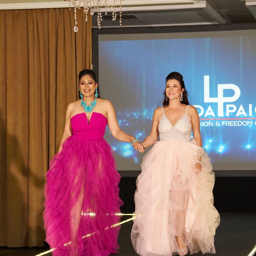 Two delegates in evening gowns on the Linda Paige runway