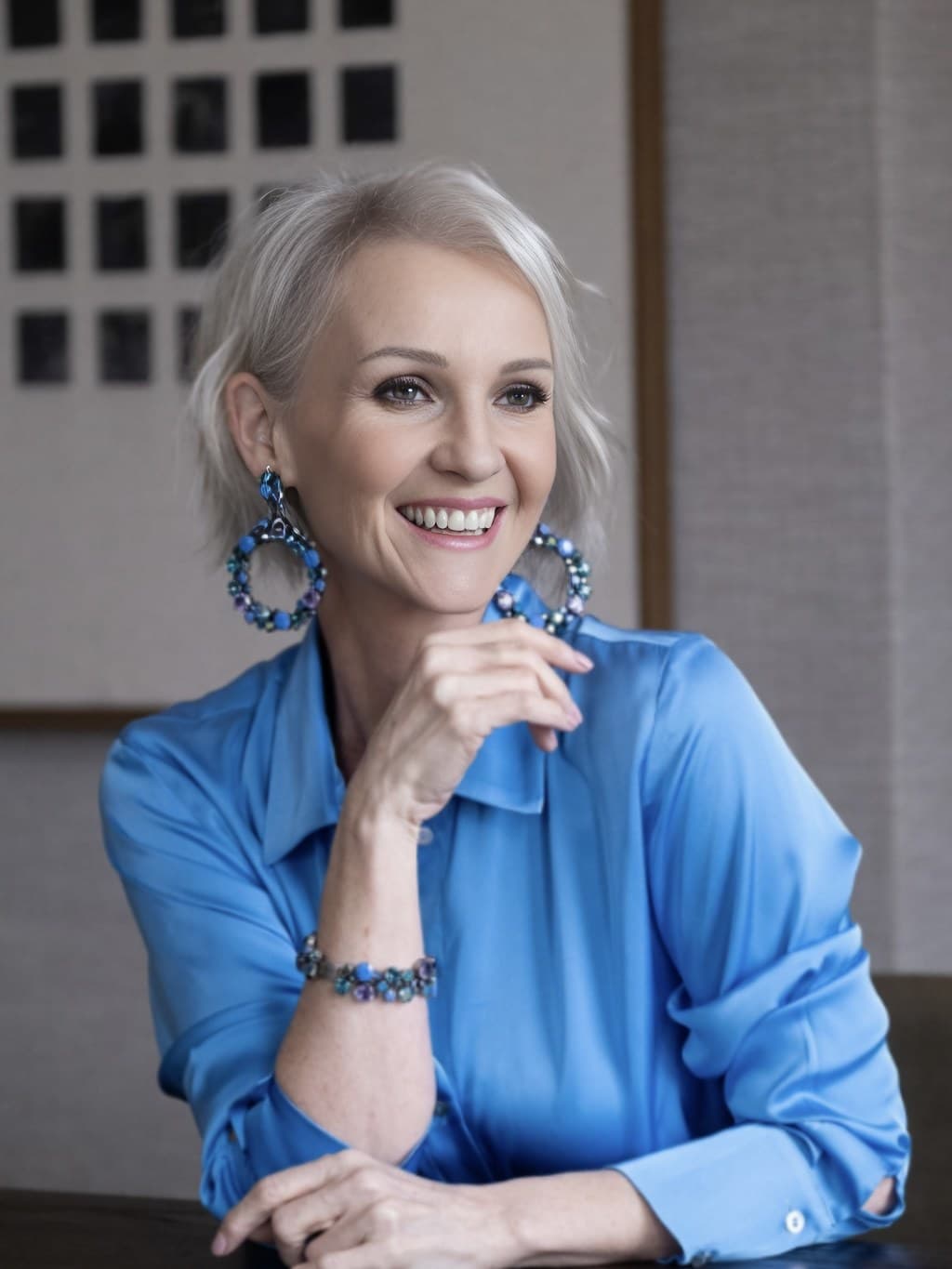 Linda Paige, smiling, in a blue silk shirt
