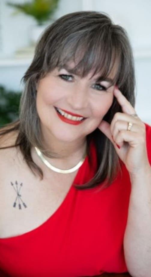 Kate, smiling, in a red one-shoulder top