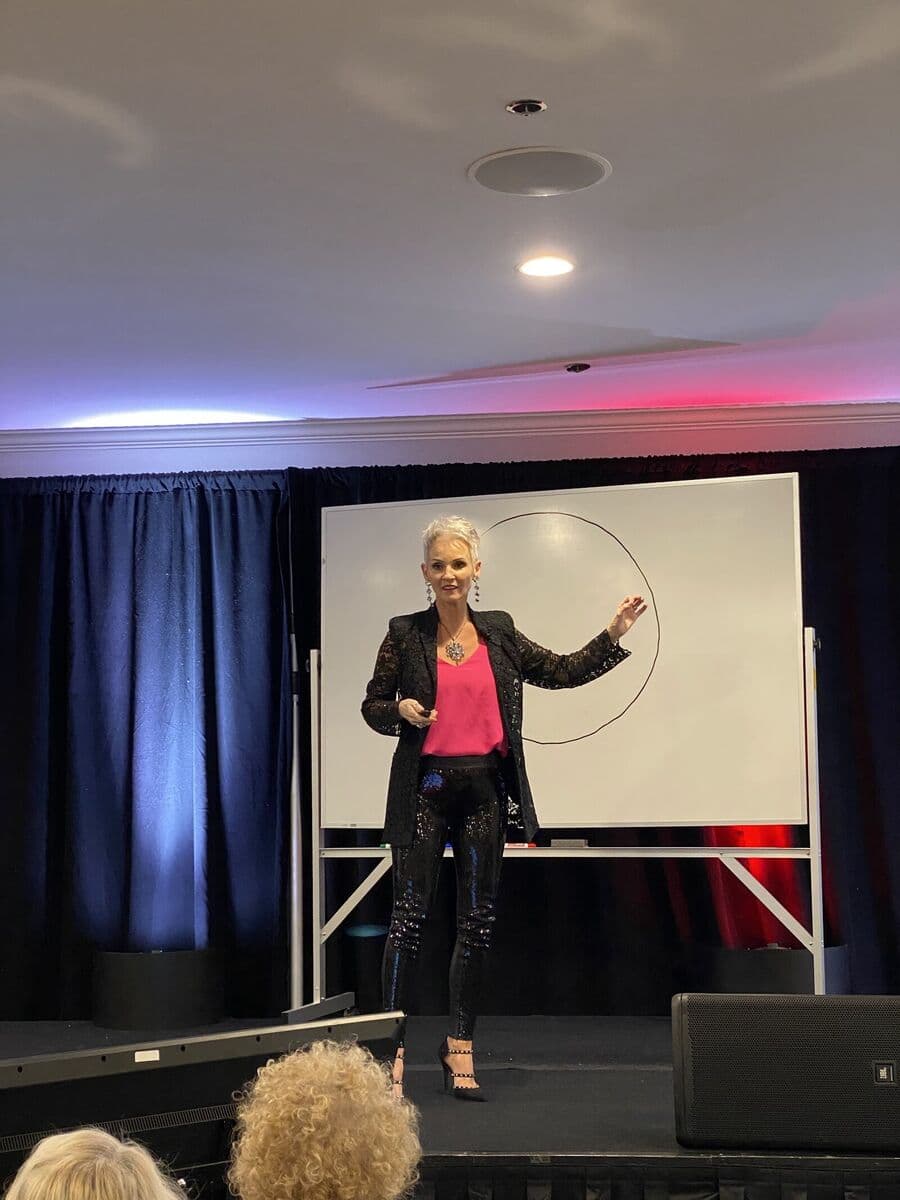 Linda teaching on stage in front of a whiteboard