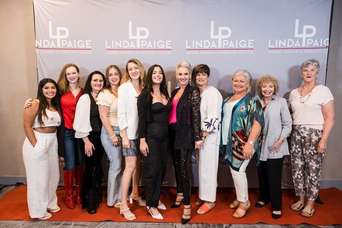 A group of women smiling together with Linda at a LindaPaige event