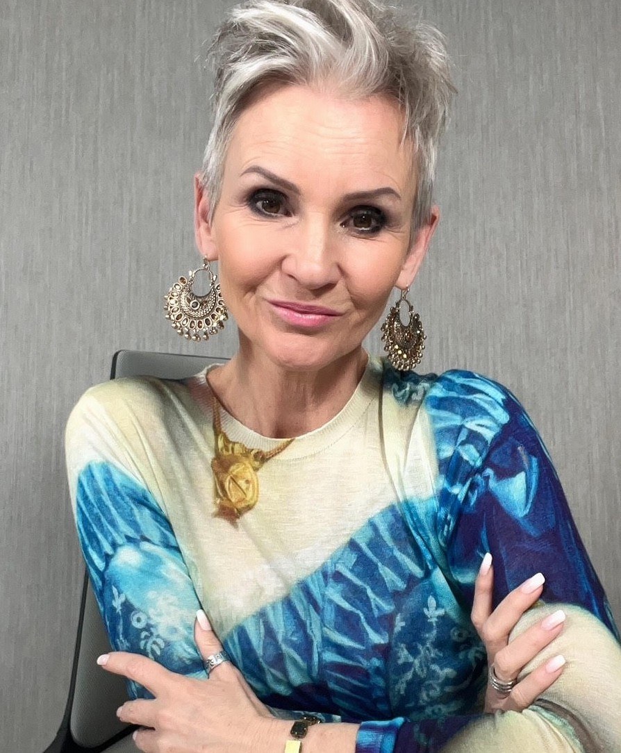 Linda Paige in a teal patterned blouse with a gold necklace